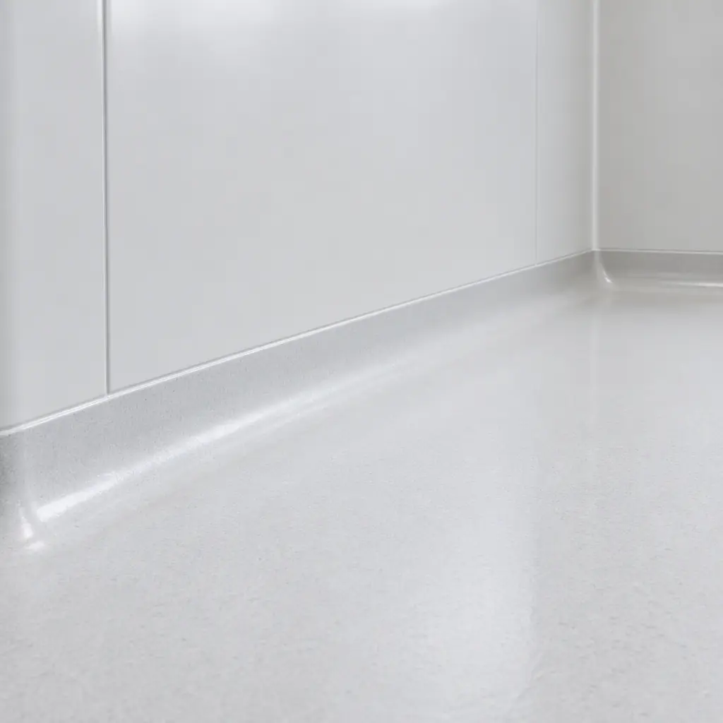 Photorealistic close-up of a smooth white cleanroom wall panel meeting a seamless floor, soft even lighting, no text